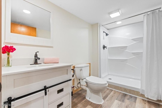 bathroom with a shower with curtain, wood finished floors, vanity, toilet, and recessed lighting