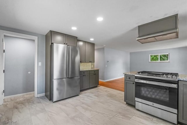 kitchen with appliances with stainless steel finishes, tasteful backsplash, gray cabinetry, baseboards, and marble finish floor