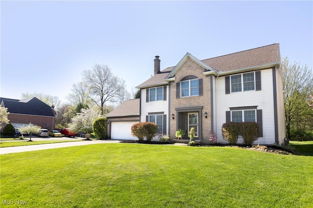 colonial inspired home with a front yard, roof with shingles, driveway, and a chimney
