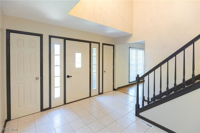 foyer featuring stairs, visible vents, and light tile patterned floors