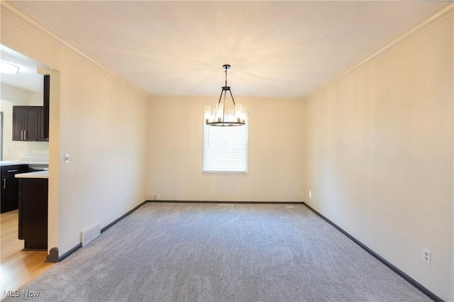 spare room featuring crown molding, an inviting chandelier, light carpet, baseboards, and visible vents