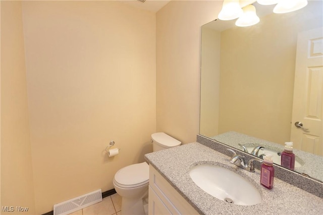 half bathroom with tile patterned floors, vanity, toilet, and visible vents