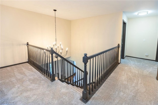 stairway with baseboards, carpet, and a notable chandelier