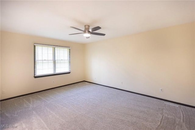 unfurnished room featuring baseboards, light carpet, and ceiling fan