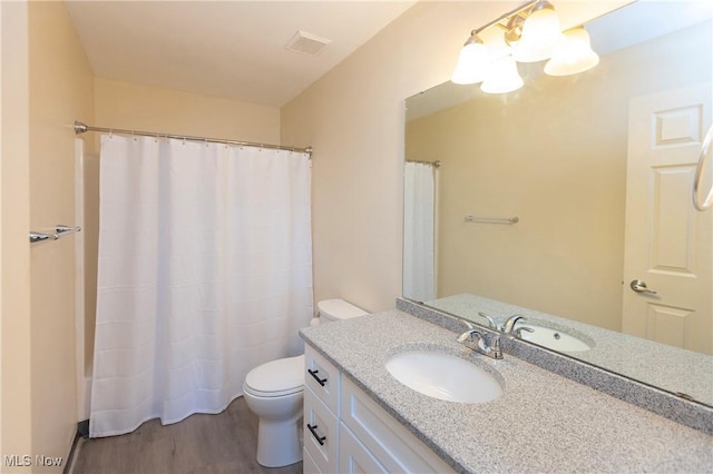 bathroom featuring vanity, visible vents, wood finished floors, toilet, and a shower with curtain