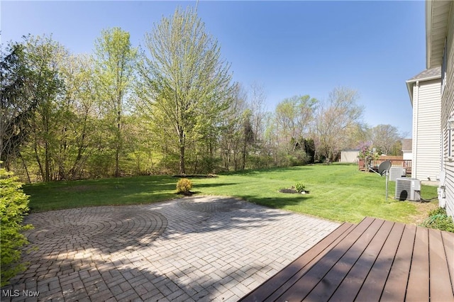 wooden terrace featuring a patio, a yard, and central AC unit