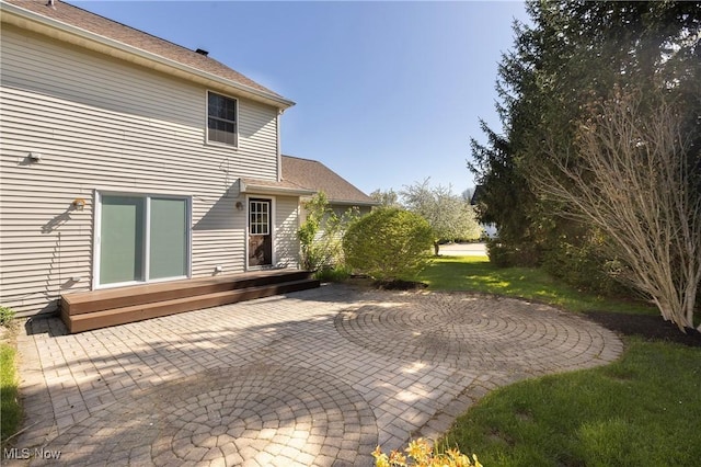 back of house featuring a wooden deck and a patio area