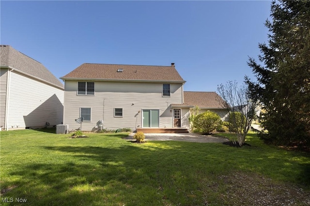 rear view of property with a lawn and central AC