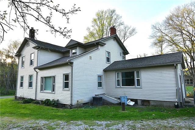 11680 Walnut Ave NE, Alliance, OH 44601 - back of house with roof with shingles, central air condition unit, a yard, and a chimney