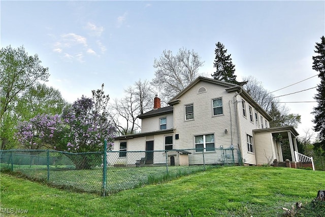 11680 Walnut Ave NE, Alliance, OH 44601 - back of house with a lawn, fence, and a chimney