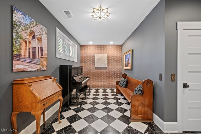 interior space with brick wall, an accent wall, recessed lighting, baseboards, and visible vents
