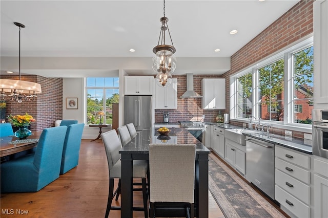 kitchen featuring a sink, appliances with stainless steel finishes, a wealth of natural light, and a chandelier