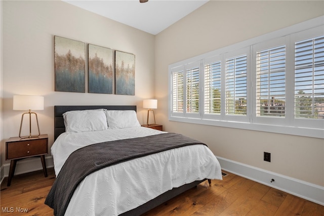 bedroom with baseboards and wood finished floors