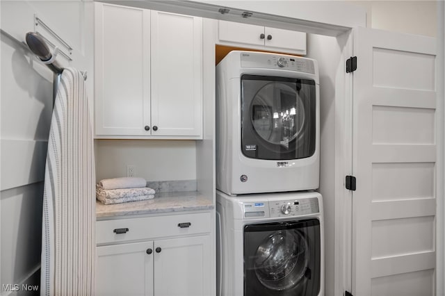 clothes washing area featuring laundry area and stacked washing maching and dryer