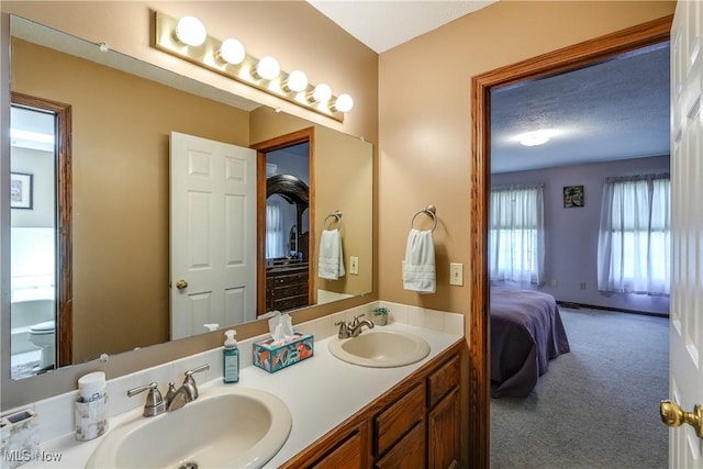 ensuite bathroom with double vanity, a sink, and connected bathroom
