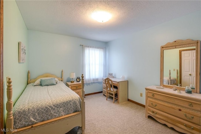 bedroom featuring light colored carpet, a textured ceiling, and baseboards