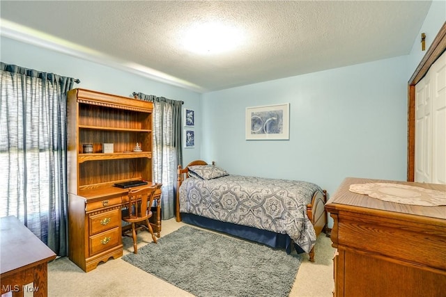 bedroom with light carpet and a textured ceiling