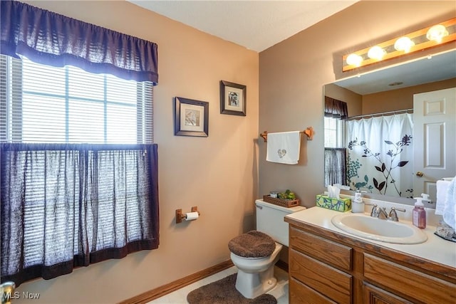 bathroom featuring vanity, baseboards, a shower with shower curtain, and toilet