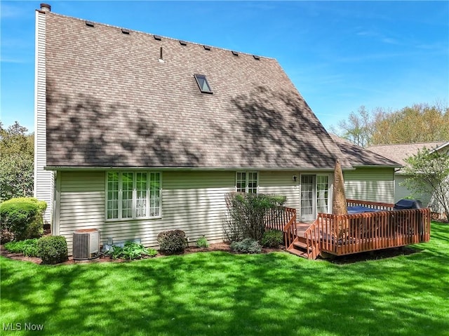 rear view of property with roof with shingles, central AC unit, a yard, and a deck