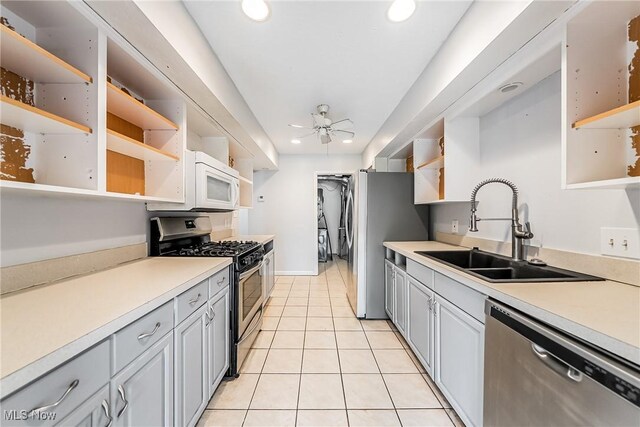 kitchen featuring open shelves, recessed lighting, a sink, light tile patterned floors, and stainless steel appliances