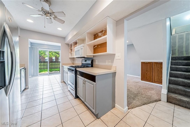 kitchen with ceiling fan, open shelves, appliances with stainless steel finishes, light countertops, and light tile patterned floors