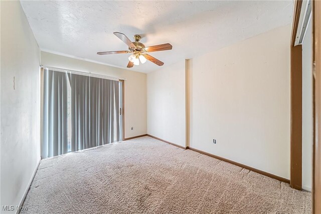 empty room with baseboards, carpet, and a ceiling fan