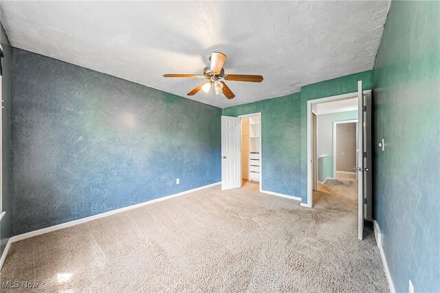 unfurnished bedroom with carpet floors, a ceiling fan, and baseboards