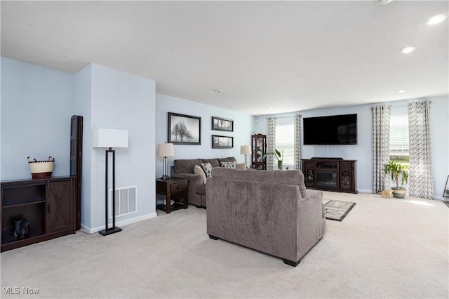 3939 Higgins Dr, Norton, OH 44203 - living area featuring light carpet, a glass covered fireplace, recessed lighting, baseboards, and visible vents