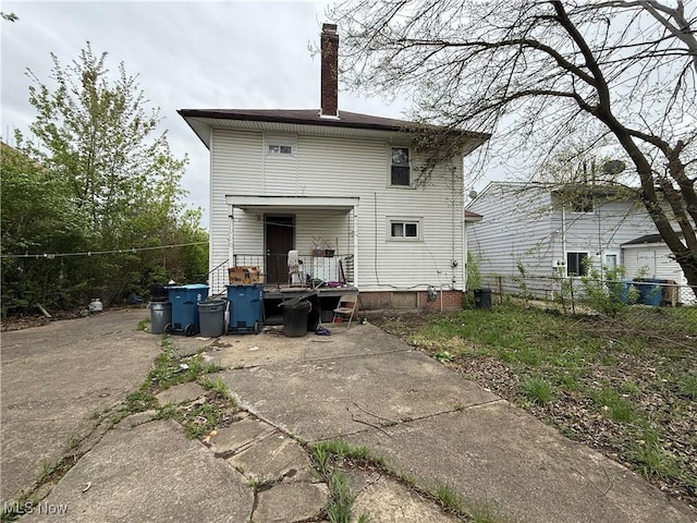 rear view of house featuring fence and a chimney