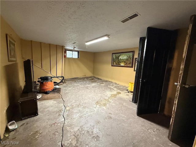 basement featuring a textured ceiling and visible vents