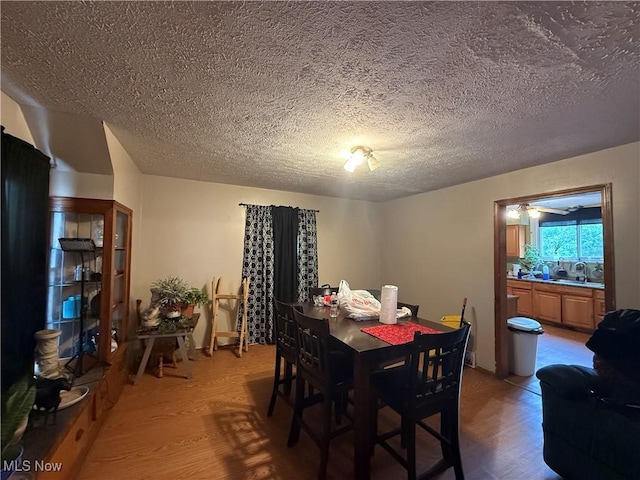 dining room with a textured ceiling and light wood-style flooring