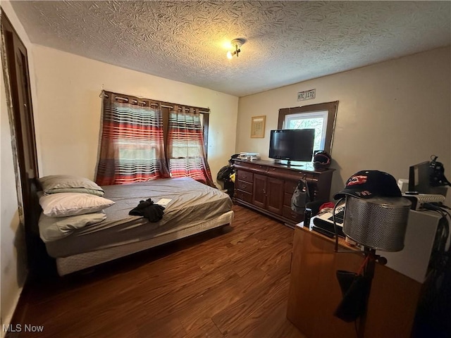 bedroom featuring dark wood-style flooring and a textured ceiling