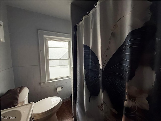 bathroom with vanity, a shower with curtain, toilet, and wood finished floors