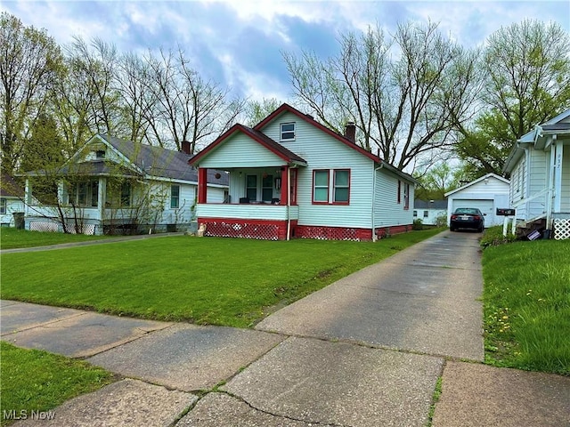 bungalow with a front lawn, a garage, an outbuilding, concrete driveway, and covered porch