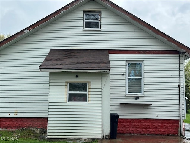 view of side of property with a shingled roof