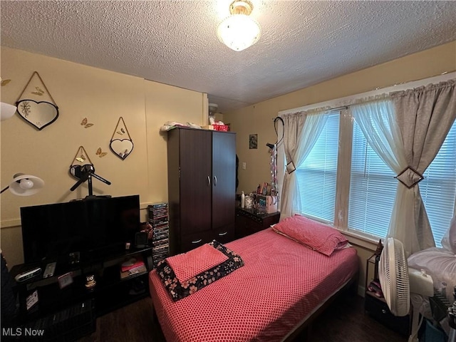 bedroom with a textured ceiling and wood finished floors