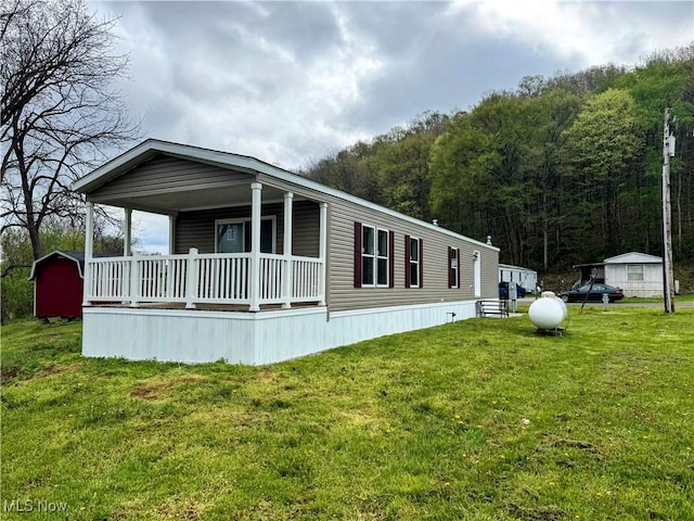 46115 US Highway 36, Coshocton, OH 43812 - view of front of property with covered porch, a view of trees, and a front yard
