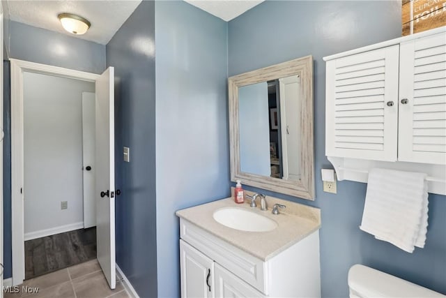 692 Roslyn Ave, Akron, OH 44320 - half bathroom with toilet, baseboards, tile patterned flooring, and vanity