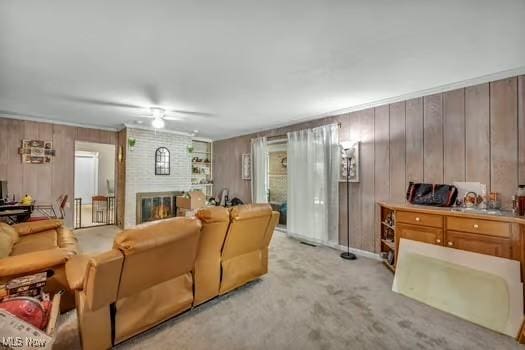 living area featuring wooden walls, a ceiling fan, light carpet, and a fireplace