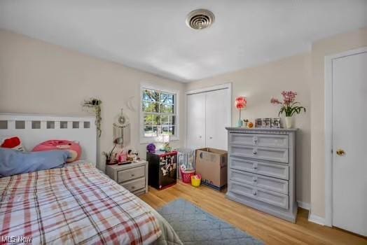 bedroom featuring a closet, light wood-style flooring, and visible vents