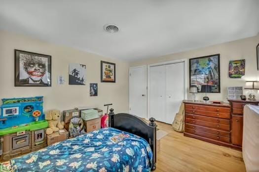 bedroom with a closet, visible vents, and light wood-type flooring