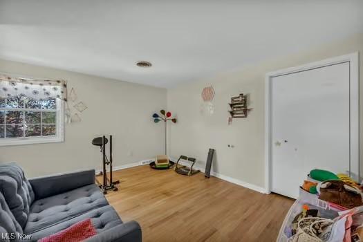 living area with baseboards and wood finished floors