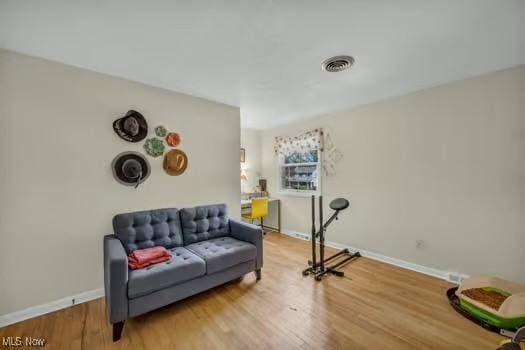 interior space featuring baseboards, visible vents, and wood finished floors