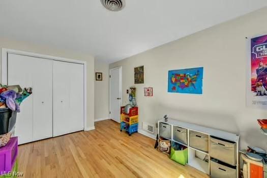 rec room with baseboards, wood finished floors, and visible vents