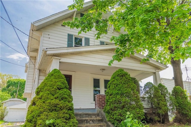 american foursquare style home featuring covered porch