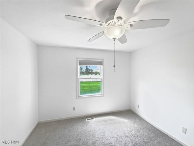 carpeted empty room with a ceiling fan, baseboards, and visible vents