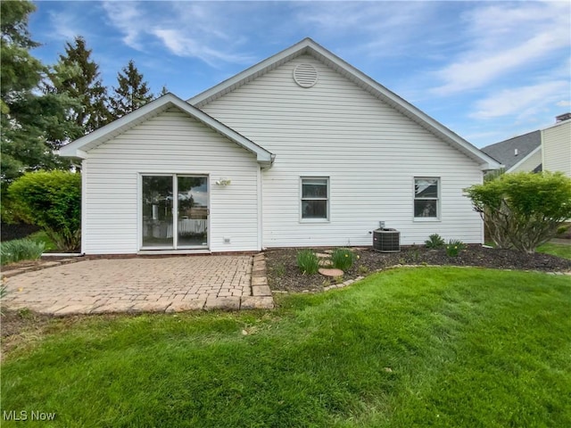 rear view of house with a yard, a patio, and central AC unit