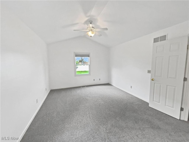 empty room featuring visible vents, carpet, a ceiling fan, baseboards, and vaulted ceiling
