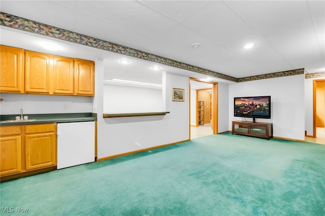 unfurnished living room featuring light colored carpet, a sink, indoor wet bar, recessed lighting, and baseboards