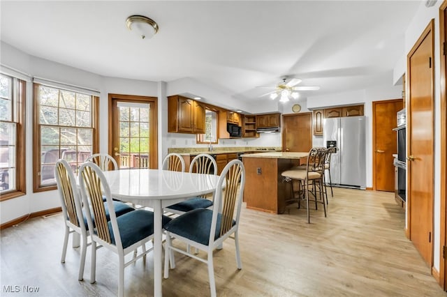 dining area featuring ceiling fan and light wood-style flooring
